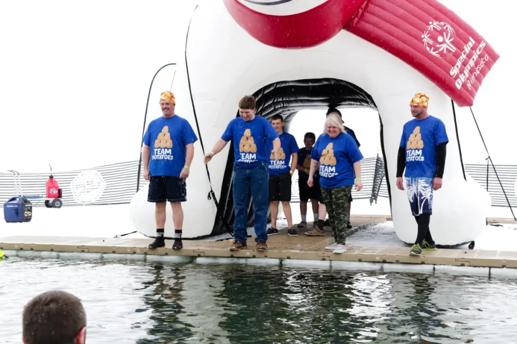 Team members standing beside inflatable polar plunge structure