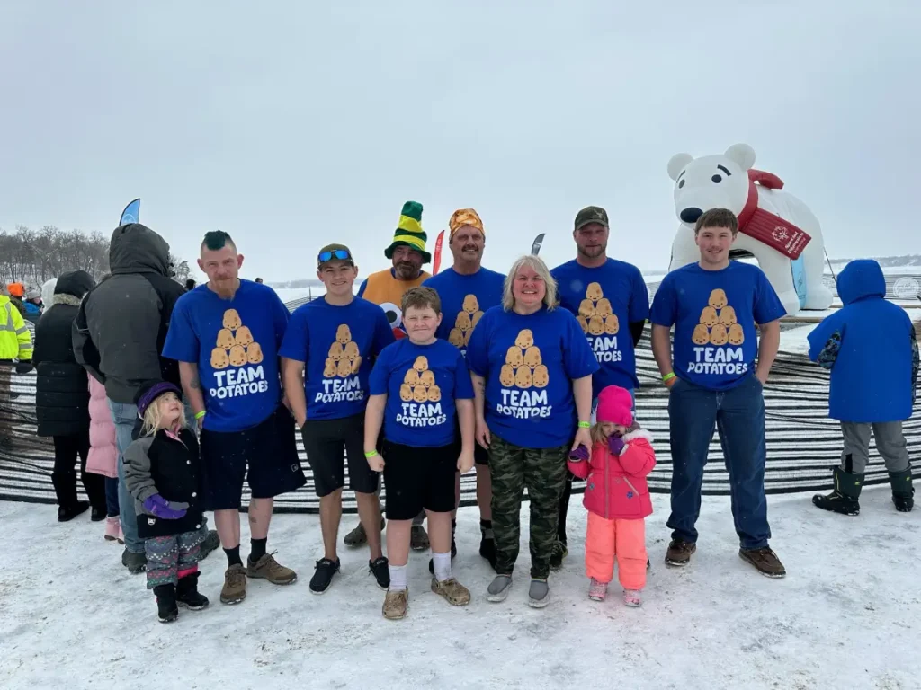 Group posing outdoors in matching Team Potato shirts during event
