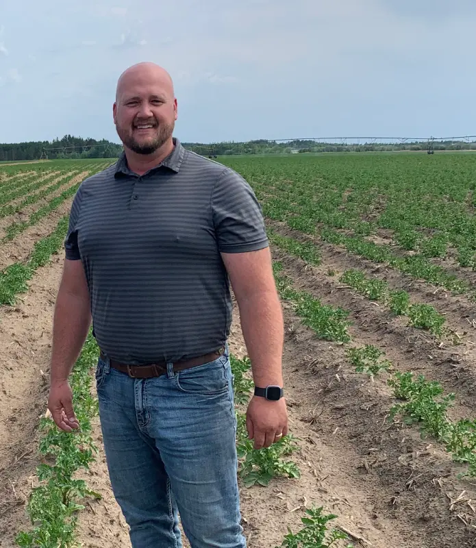 Farmer standing in cultivated field during growing season