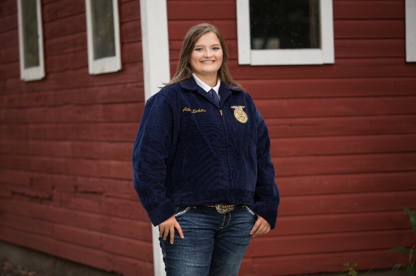 Annika Merkens, smiling outside of red building
