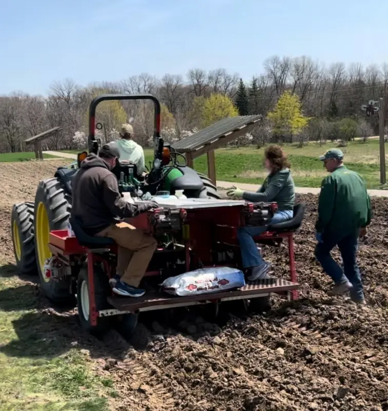 People working outdoors with agricultural equipment