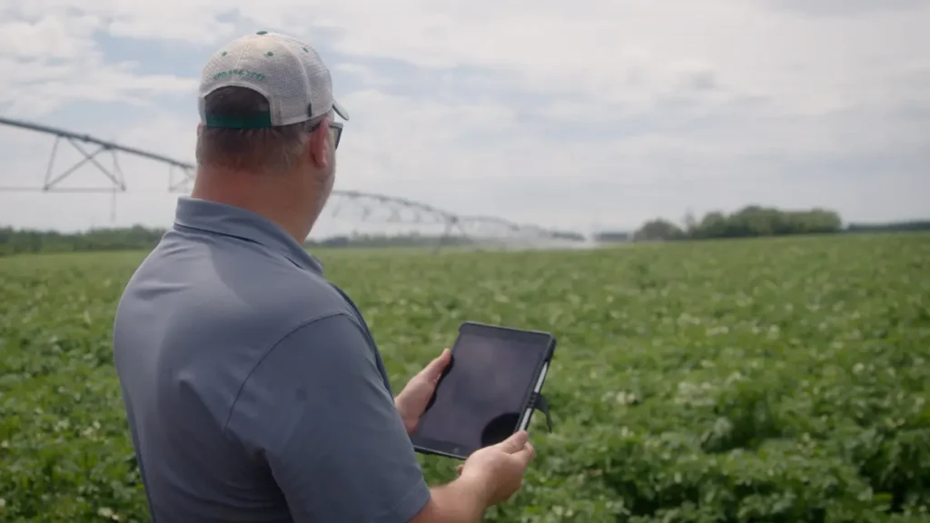 Farmer using tablet in irrigated crop field