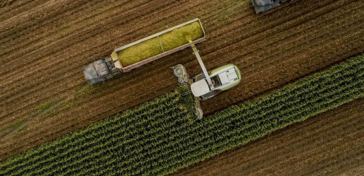 Aerial view of agricultural equipment working in field rows