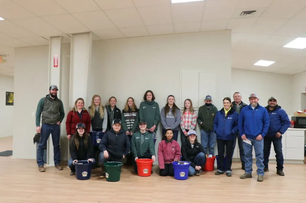 Group posing indoors with buckets