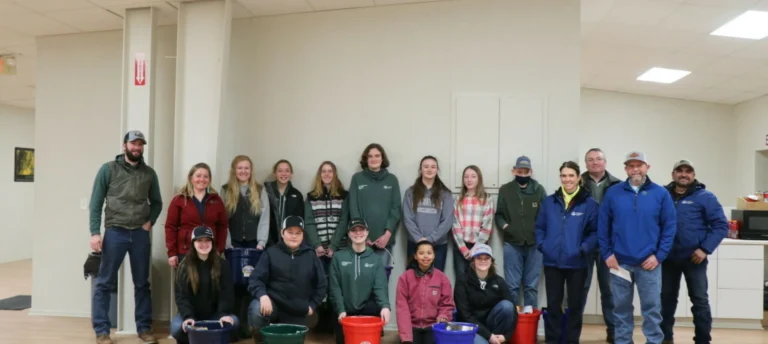 Group posing indoors with buckets