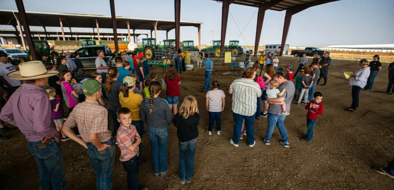 Group gathered inside open-sided agricultural structure