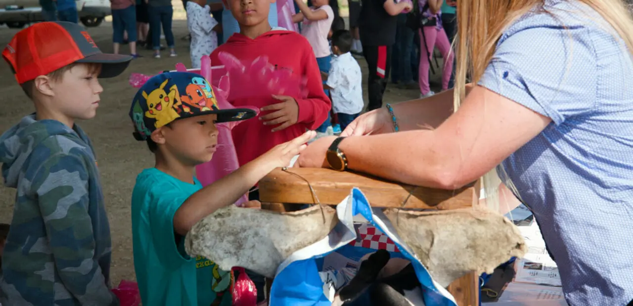Person handing items to child outdoors