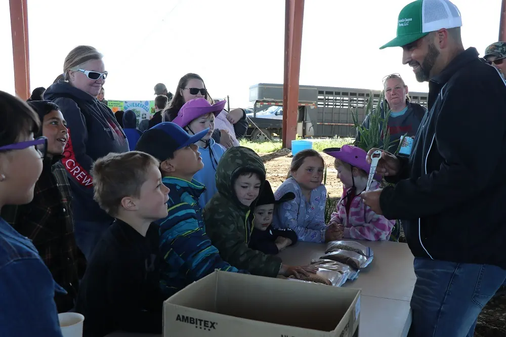 Children gathered around outdoor activity table