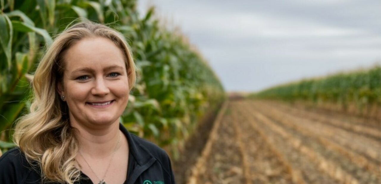 Amelia standing beside crop rows in field
