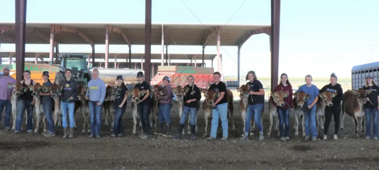 Group posing under open-sided livestock structure