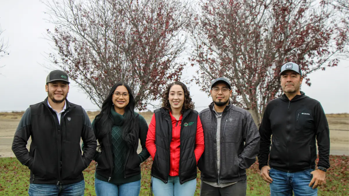 Group posing outdoors beside flowering trees