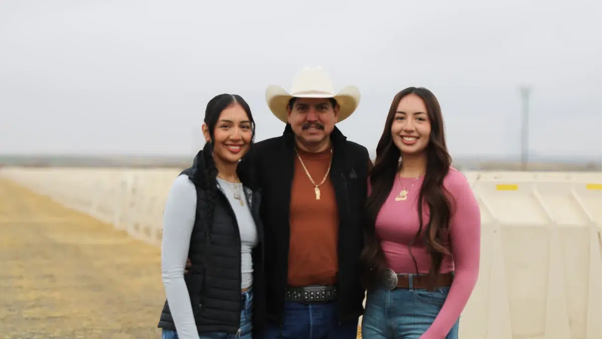 Three people posing together outdoors
