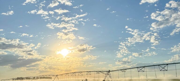 Irrigation system spraying water at sunrise