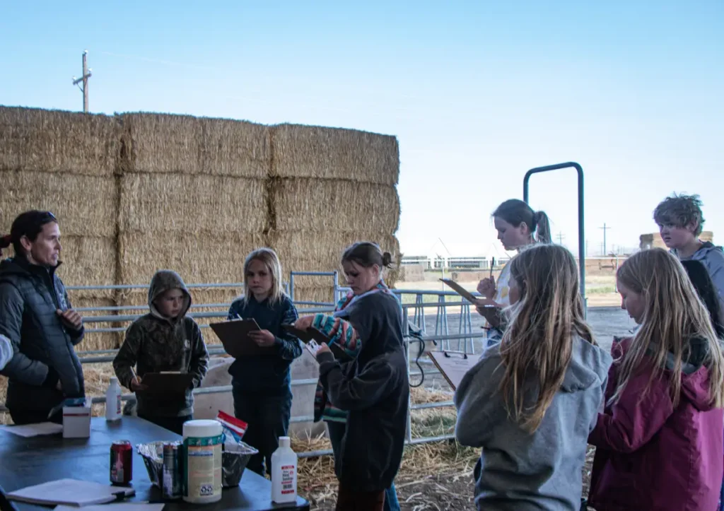 People gathered under open-sided farm structure