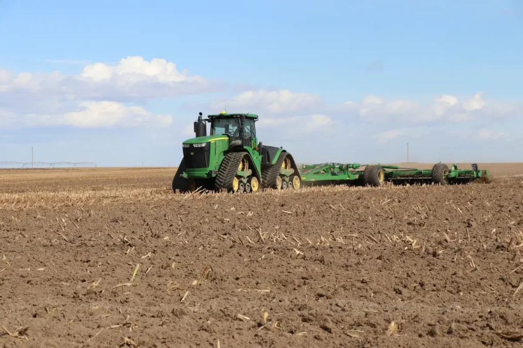 Tractor working across cultivated farmland