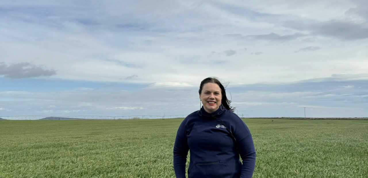 Woman standing in open grassy field