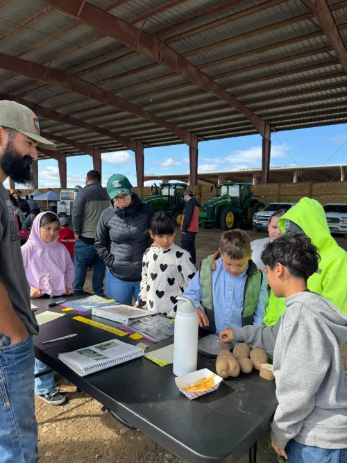 People gathered at outdoor agricultural workshop