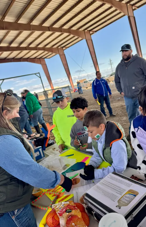 Children participating in hands-on agricultural activity outdoors