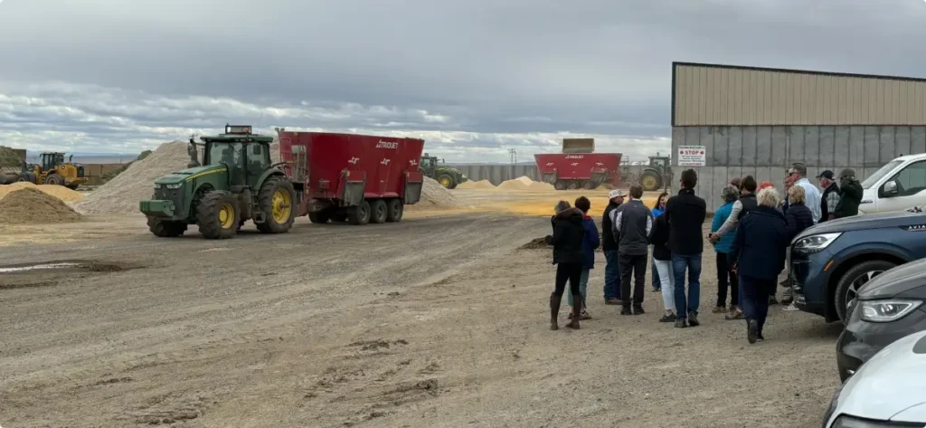 People standing near farm equipment on dirt road