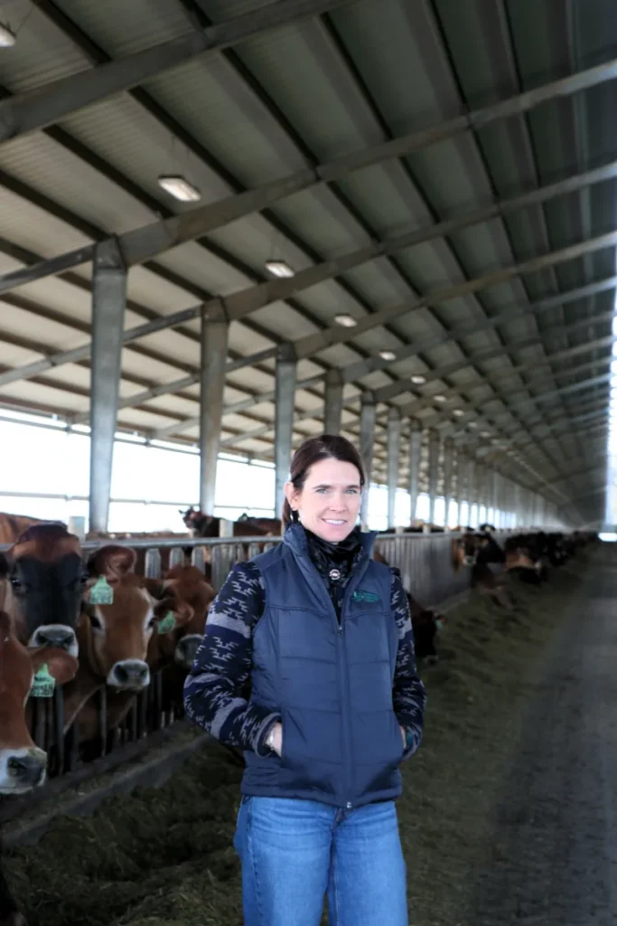 Person standing inside large livestock barn