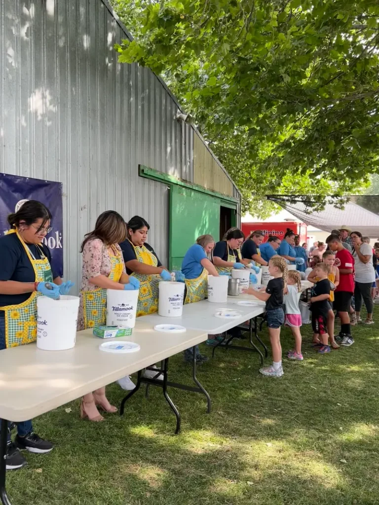 Volunteers serving ice cream outdoors at community event