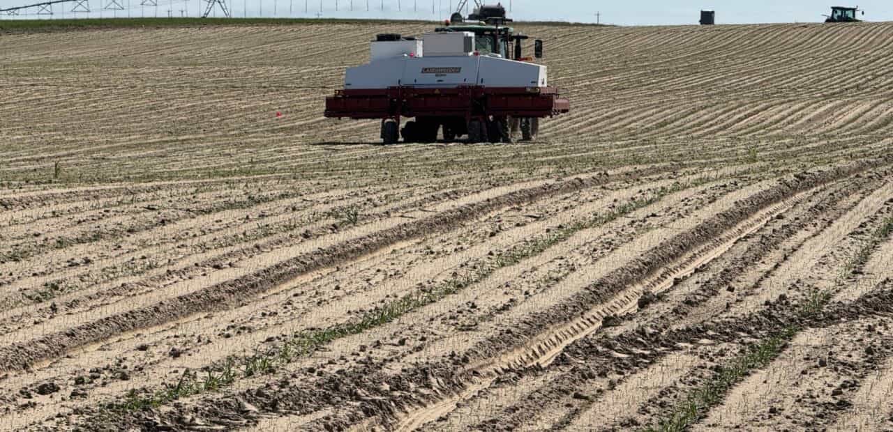 Agricultural vehicle working across planted field