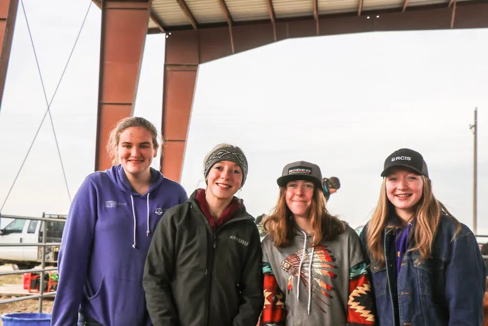 Group posing together under open-sided structure