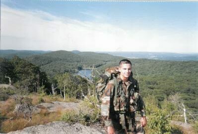 Nick, standing outdoors in camouflage