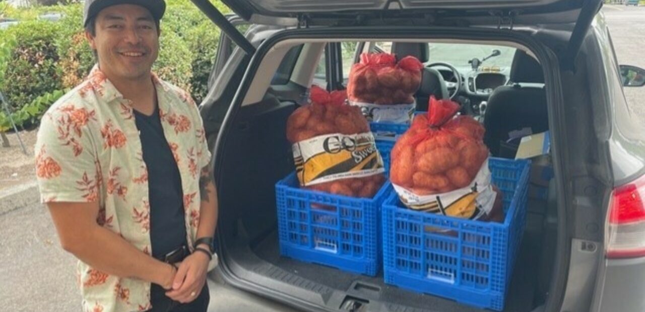 Crates of fresh produce in open vehicle trunk